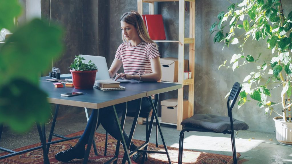 Une collaboratrice travaille sur son ordinateur portable dans un bureau lumineux